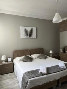 a bedroom with a large white bed and two lamps at F11 Modern and Bright Apartment in Malta in Msida