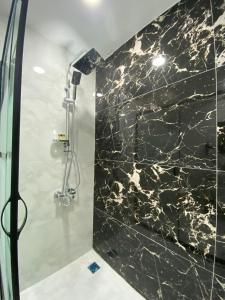 baño con ducha y pared de mármol negro. en X Premium en Kayseri