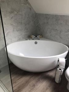 a white bath tub in a bathroom with a toilet at Llysfaen Cottage in Brecon