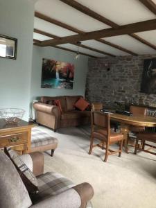 a living room with a couch and a table at Llysfaen Cottage in Brecon