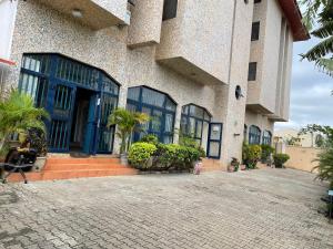 a building with blue doors and windows on a street at Best Yessit Homestay in Abuja