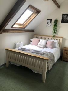 a bedroom with a large bed with a skylight at Llysfaen Cottage in Brecon