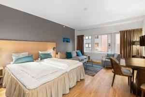 a hotel room with a large bed and a desk at First Hotel City Tromsø in Tromsø