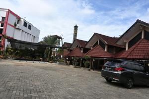 a car parked on a street next to a building at Rimbawan Guest House in Lampung