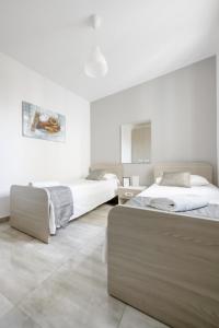 two beds in a bedroom with white walls at F12 Modern and Bright Apartment in Malta in Msida
