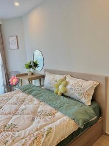 a bedroom with a bed with flowers on it at Căn hộ The Sóng - Hedone home in Vung Tau