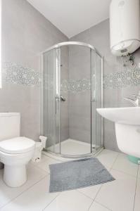 a bathroom with a shower and a toilet and a sink at F12 Modern and Bright Apartment in Malta in Msida