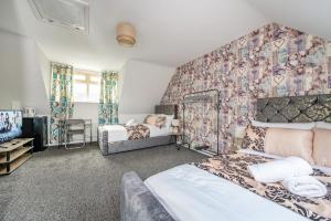 a bedroom with two beds and a wall covered in wallpaper at *RA27R* For your most relaxed & Cosy stay + Free Parking + Free Fast WiFi * in Kirkstall