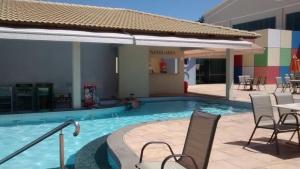 una piscina en un hotel con sillas y una mesa en Resort Lacqua Park DiRoma, en Caldas Novas