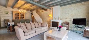 ein Wohnzimmer mit einem Sofa und einem Kamin in der Unterkunft Magnifique maison de village rhétaise in Sainte-Marie-de-Ré