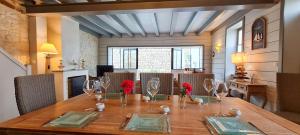 a dining room table with red flowers on top of it at Magnifique maison de village rhétaise in Sainte-Marie-de-Ré
