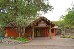 un petit bâtiment orange avec un panneau. dans l'établissement Kia Lodge, à Arusha