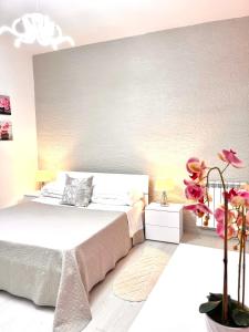 Un dormitorio con una gran cama blanca y una planta en Stefy's House, en Scalea