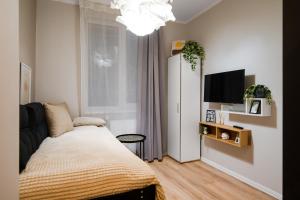 een slaapkamer met een bed en een flatscreen-tv bij Tom Thumb & Thumbelina ~ 2 Private Rooms in Sofia Center in Sofia