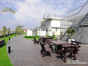 a patio with wooden tables and benches on a building at 5D Homestay in Sitiawan