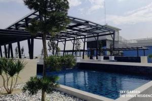 a swimming pool in a resort with a bridge in the background at 5D Homestay in Sitiawan