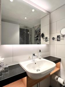 a white bathroom with a sink and a mirror at Holiday Inn Edinburgh Zoo, an IHG Hotel in Edinburgh