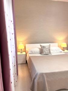 a bedroom with two beds and two lamps on tables at Stefy's House in Scalea