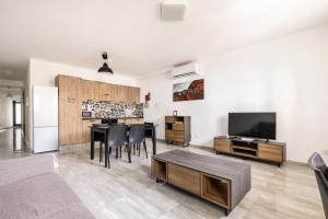 een woonkamer met een tafel en een flatscreen-tv bij F8 Room 1, Private Double room with private bathroom in shared Flat in Msida