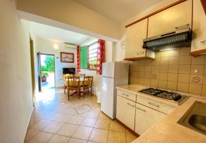 cocina con nevera, mesa y sillas en Apartments Malvina, en Rovinj