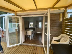 a screened in porch with a sliding glass door at MOBIL HOME Clim BOOFZHEIM 6 PERSONNES 3 CHAMBRES LE RIED 3 ETOILES PROCHE EUROPA PARK in Boofzheim