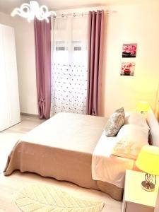 1 dormitorio con 1 cama grande y cortinas rosas en Stefy's House, en Scalea