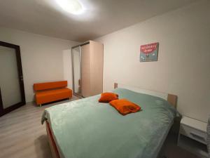 キーウにあるАпартаменты на Нежинской 29Г недалеко от Индустриального мостаのベッドルーム1室(オレンジ色の枕2つ付)