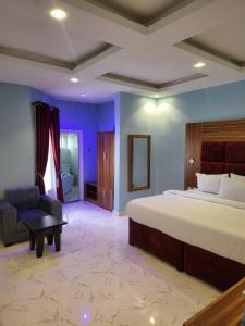 1 dormitorio con 1 cama, 1 sofá y 1 silla en M View Hotel, en Benin City