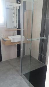 uma casa de banho com uma cabina de duche em vidro e um lavatório. em MAISON d'architecte Plage à Pied em Sanary-sur-Mer
