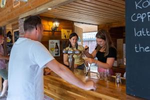a group of people standing at a bar making drinks at Camping Leef! in Melderslo