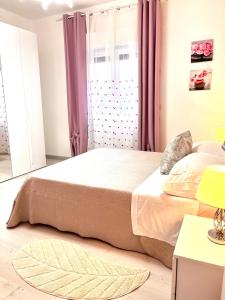 1 dormitorio con 1 cama grande y cortinas rosas en Stefy's House, en Scalea