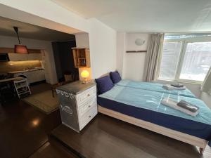 a bedroom with a bed with a blue comforter at Cozy studio stay in Sofia in Sofia