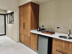 una cocina con armarios de madera y fregadero en Bushbaby Valley Lodge, en Hazyview