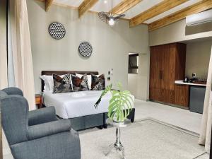 ヘイジービューにあるBushbaby Valley Lodgeのベッドルーム1室(ベッド1台、ソファ、椅子付)