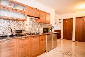 eine Küche mit Holzschränken und Geräten aus Edelstahl in der Unterkunft U Ireny in Zakopane