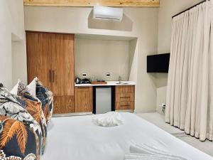 a bedroom with a bed and a kitchen with a sink at Bushbaby Valley Lodge in Hazyview