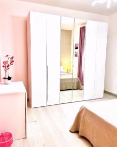 1 dormitorio con armarios blancos y espejo grande en Stefy's House, en Scalea