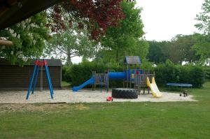 um parque infantil com um escorrega e um equipamento de brincar em Camping Leef! em Melderslo