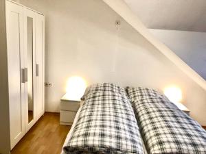 ein Bett mit zwei karierten Kissen in einem Zimmer in der Unterkunft Lotus Apartment in Fichtenberg