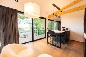 een woonkamer met een tafel en stoelen en een balkon bij Gîte : Le Petit Appentis in Profondeville