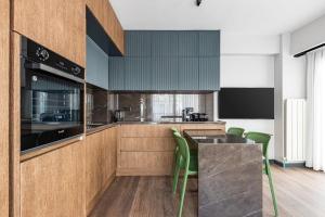 een keuken met houten kasten en groene stoelen bij Charming Bright New 2bd1bath Home Wparking!#339 in Istanbul