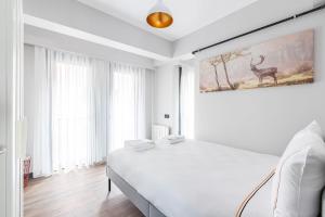 een witte slaapkamer met een bed en een schilderij van een hert bij Charming Bright New 2bd1bath Home Wparking!#339 in Istanbul