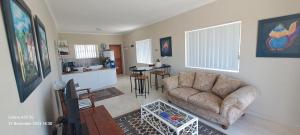 a living room with a couch and a kitchen at Top Deck in Struisbaai