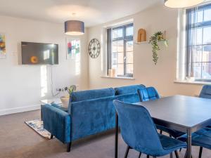 a living room with a blue couch and a table at Pass the Keys Beautiful 1 bedroom apartment in Nottingham