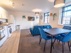 a living room with a table and a blue couch at Pass the Keys Beautiful 1 bedroom apartment in Nottingham