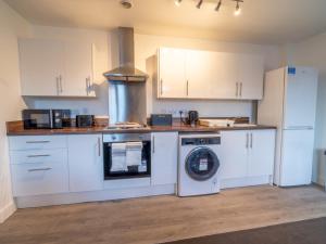 a kitchen with a washing machine and a refrigerator at Pass the Keys Beautiful 1 bedroom apartment in Nottingham