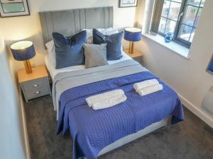 a bedroom with a large bed with blue sheets and pillows at Pass the Keys Beautiful 1 bedroom apartment in Nottingham