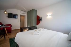 a bedroom with a white bed with a table and a chair at Guesthouse diWINE in Merano