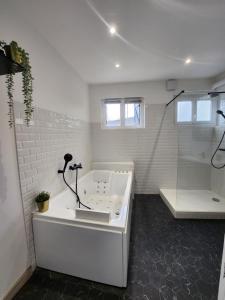 y baño blanco con bañera y ducha. en Détente en centre-ville, en Rouen