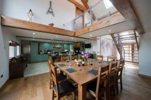 a dining room with a large wooden table and chairs at Oak Barn in Brecon